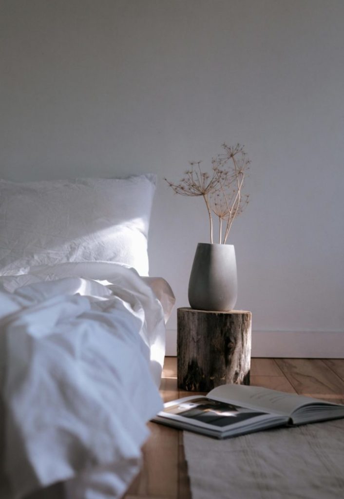 Photo by PNW Production: https://www.pexels.com/photo/a-white-bed-with-linen-near-the-chopped-wood-with-ceramic-vase-on-top-8251666/